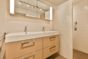 a bathroom with two sinks and mirrors on the wall above it is an image of a mirror over the sink- bathroom cabinets in San Antonio